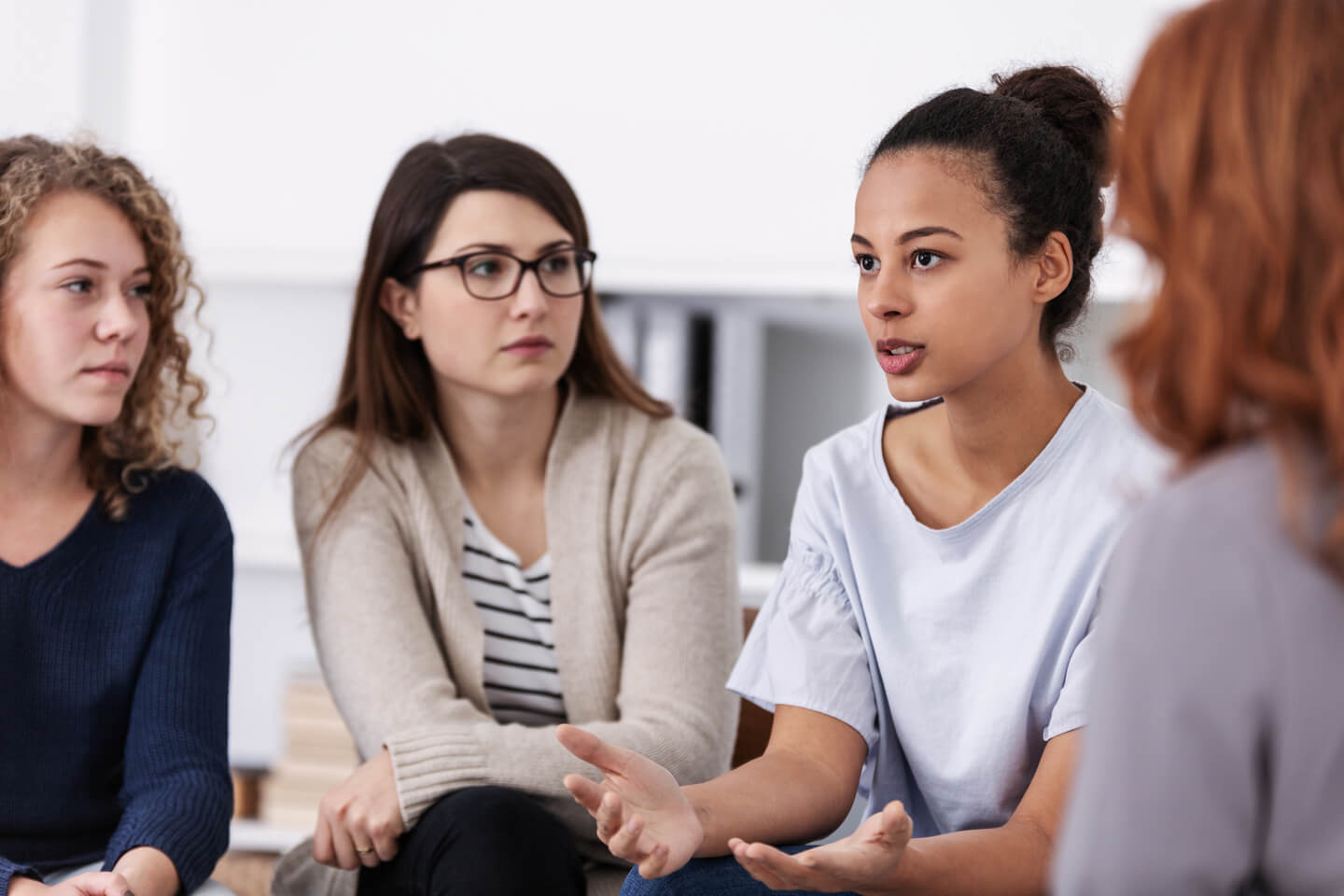 Four women in a support group speaking to one another.